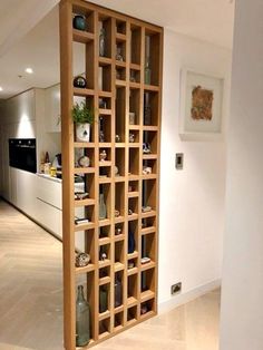 an open bookcase in the middle of a room with white walls and wood flooring