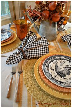 a table set with plates, silverware and napkins for an elegant thanksgiving dinner