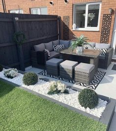 an outdoor patio with grey furniture and white pebbles