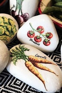 painted rocks with vegetables on them sitting on a table