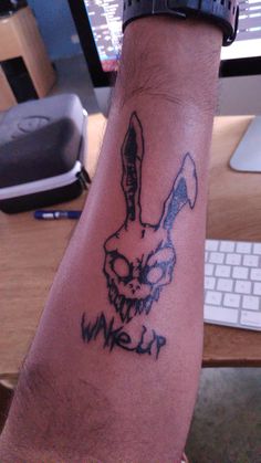 a man with a tattoo on his arm has a knife in the shape of a rabbit