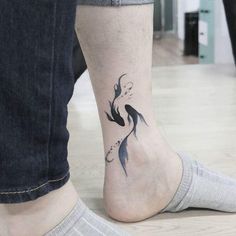 a person with a fish tattoo on their foot