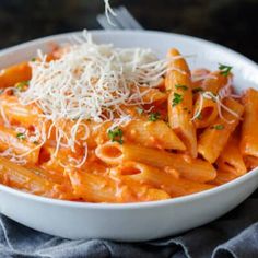 a white bowl filled with pasta and parmesan cheese