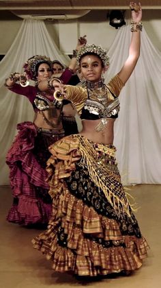 two women dressed in elaborate clothing dance together