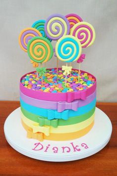 there is a cake decorated with lollipops and sprinkles on top