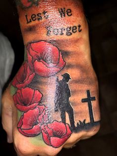 a person with a cross and flowers on their hand that says, let's we forget