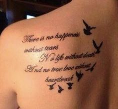 the back of a woman's shoulder with birds flying around it and an inscription that says