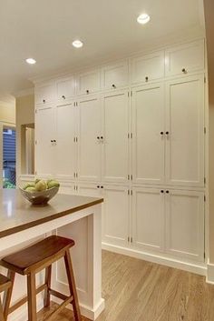 a large kitchen with white cabinets and an island