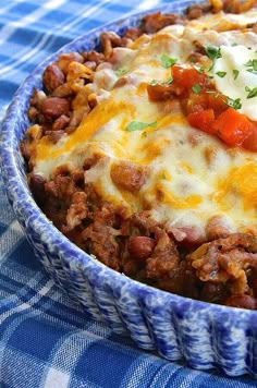 a casserole dish with meat and vegetables in it on a blue table cloth