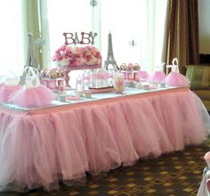 a table with pink tulle skirt and cake