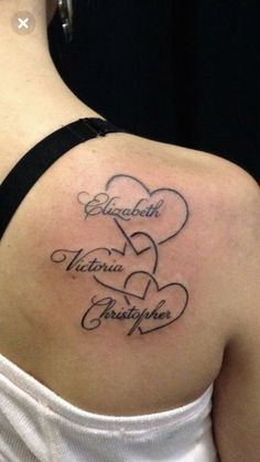 the back of a woman's shoulder with two hearts and name tattoos on it