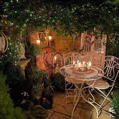 an outdoor table and chairs with lit candles