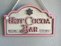 a sign hanging from the side of a wall that says hot cocoa bar and marshmallows peppermints