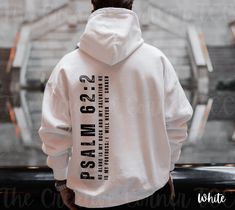 Introducing our Christian Men's Hoodie, a stylish and meaningful addition to your wardrobe. Crafted with comfort in mind, this hoodie is perfect for the modern Christian man who seeks both fashion and faith. The back design proudly features Psalms 62:2, a powerful verse that declares, "He alone is my rock and my salvation, my fortress where I will never be shaken." Made from high-quality materials, this hoodie ensures both warmth and durability. The minimalist front design maintains a clean and Christian Sweatshirts Storage, Christian Jackets, Christian Hoodies Men, Psalms 62, Bible Verse Hoodies, Men’s Christian Hoodies, Faith Based Sweatshirts, Christian Clothing Brand, Psalm 62