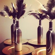 three vases with feathers in them are sitting on the table, ready to be used as centerpieces