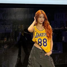 a woman with red hair wearing a lakers jersey