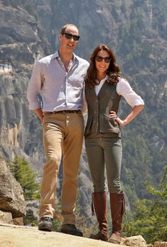 a man and woman standing on top of a mountain