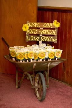 an old wheelbarrow with sunflowers on it and some tags attached to the wheels