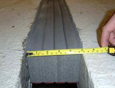 a person measuring the width of a concrete slab