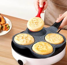 a person is cooking food in a pan on the table next to other plates and utensils