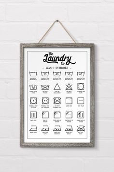 the laundry wash symbols poster hanging on a brick wall