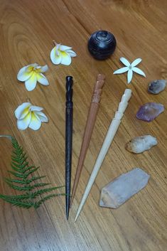 several items are arranged on a wooden surface with flowers and rocks around them, including an umbrella