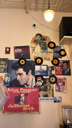 there are many records on the wall with elvis presley pictures hanging from it's walls