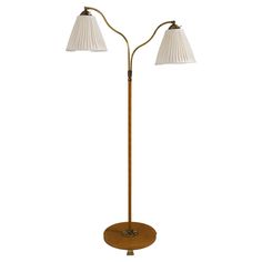 a wooden floor lamp with two white shades on the lampshade and one light