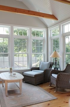 a living room filled with furniture and large windows