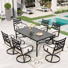 an outdoor dining table with chairs around it and a pool in the backround