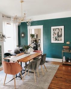 a dining room with green walls and wooden floors