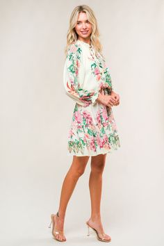 A printed woven mini dress featuring ruffled neckline with front tie, long sleeve, elasticized waist and ruffled hemline Details: Self : 100% PolyesterLining: 100% Polyester Size & Fit - Model is 5`7" And Wearing Size Small- Measurements Taken From Size Small- Approx. Length: 35" Vacation Long Sleeve Dress With Blouson Sleeves, Daywear Mini Dress With Blouson Sleeves, Long Sleeve Dresses With Blouson Sleeves For Vacation, Long Sleeve Printed Mini Dress For Brunch, Long Sleeve Mini Dress With Ruffle Hem For Vacation, Printed Long Sleeve Mini Dress For Brunch, Casual Vacation Dresses With Blouson Sleeves, Casual Dresses With Blouson Sleeves For Vacation, Spring Mini Dress With Blouson Sleeves For Brunch