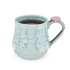 a blue mug filled with tea on top of a white table