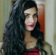 a woman with long black hair and red lipstick