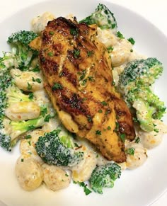 a white plate topped with chicken, broccoli and cauliflower