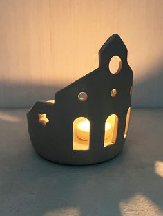 a small black object with holes in the middle and light coming from it's side