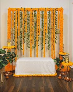 an arrangement of orange flowers and greenery decorates the backdrop for a wedding ceremony