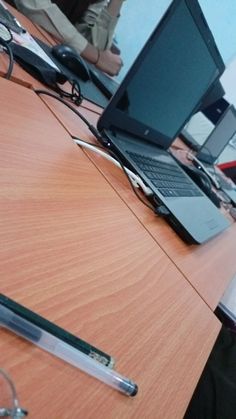 an open laptop computer sitting on top of a wooden desk