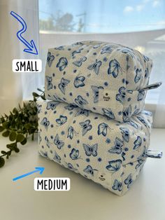 two blue and white bags sitting on top of each other