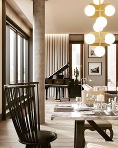 an elegant dining room with chandelier and piano in the background