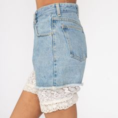 "Vintage 80s cut off denim shorts in blue denim with lace trim. Every garment we sell is authentic vintage and one-of-a-kind! You will receive the exact item photographed. Condition: Very good vintage. Has a couple faint spots that should come out with cleaning. Best fits women's: Extra small/24 Material: denim MEASUREMENTS Taken from seam to seam while the garment is lying flat. Double the armpit, waist, and hips For reference, model is 5'10\" and measures 31-23-34. Waist: 12\" Hips: 19\" Insea High Waist Cotton Bottoms With Lace Trim, High-waist Cotton Bottoms With Lace Trim, Fitted Denim Bottoms With Lace Trim, Denim Bottoms With Lace Trim For Summer, Summer Denim Bottoms With Lace Trim, Vintage Bottoms With Lace Trim For Summer, Vintage Lace Trim Bottoms For Summer, Lace Trim Shorts For Spring, Short Leg Bottoms With Lace Trim For Spring