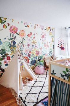 a child's room with floral wallpaper and teepee tent