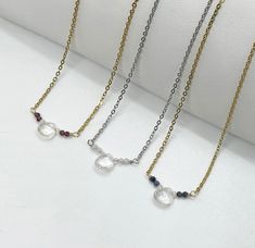 "Dainty Minimalist Sparkling Genuine Gemstone Birthstone Necklace. A shimmering little rock crystal teardrop is surrounded by tiny micro-faceted crystals and gemstones (your choice). Tarnish resistant stainless steel chain (adjustable from 15\" to  17\") with lobster clasp closure. Comes on card as shown. Makes a great birthday gift. Comes in a gift bag.  DETAILS:  Measurements (approximate): Beaded section 5/8\"-3/4\". Teardrop - 1/4\". Gemstones - 2mm. Chain length - 17\" (15\" plus 2\" extender). Chain width 1.5mm. Materials: Stainless steel. Gold tone plated stainless steel. Silver tone nickel wire. Gold tone plated copper wire. Genuine precious and semi-precious gemstones. Rock Crystal.  Garnet JANUARY Amethyst FEBRUARY Aquamarine MARCH Herkimer Diamond APRIL Emerald MAY Moonstone JUN Gift Teardrop Faceted Bead Crystal Necklace, Minimalist Teardrop Birthstone Crystal Necklace, Dainty Crystal Teardrop Pendant Necklace For Jewelry Making, Bag Details, Teardrop Necklace, Great Birthday Gifts, Herkimer Diamond, Faceted Crystal, Rock Crystal