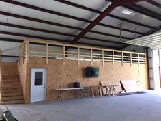 an empty warehouse with tables and chairs in the center, next to a doorway that leads into another room