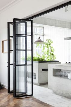 an open glass door leading to a kitchen