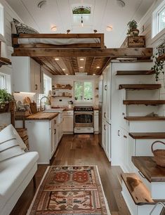 the interior of a tiny home with wood flooring and white walls, along with wooden stairs