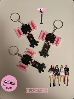 the key chain is made out of legos and has two girls in pink dresses