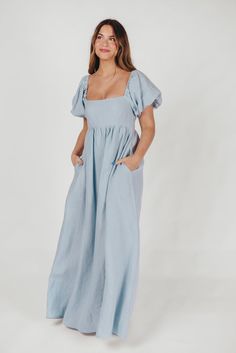 Join us in welcoming the *breathtaking* Candace Maxi Dress to the Worth Collective repertoire - we know you're going to love her! This pastel-hued, 100% linen dress is the epitome of elegance and luxury. Its beautiful neckline frames your decolletage, while the gently puffed sleeves and full skirt accent this gown's exquisite craftmanship. It's the perfect choice for this season's weddings, photo shoots, and other special events! FIT: Runs true to size. Empire waist and smocked bodice will accom Chic Blue Linen Maxi Dress, Fitted Blue Linen Dress, Blue Linen Maxi Dress With Short Sleeves, Fitted Linen Maxi Dress For Spring, Blue Linen Short Sleeve Maxi Dress, Blue Fitted Linen Midi Dress, Fitted Blue Linen Dress For Daywear, Blue Maxi Linen Dress, Blue Linen Maxi Dress