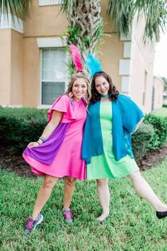 two women dressed in colorful outfits posing for the camera with their arms around each other