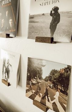 several pictures are hanging on the wall in front of some books and cds, including one with an image of elvis presley